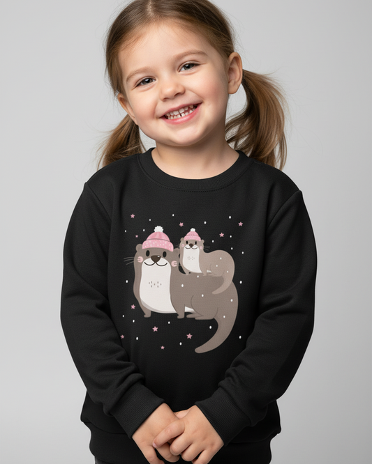 Smiling child wearing black winter otter sweatshirt on a light studio background, cute mum and baby otter design for kids