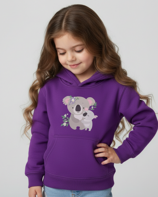 Little girl modelling a purple children’s hoodie with adorable koala and baby koala design, looking down in a soft studio setting.