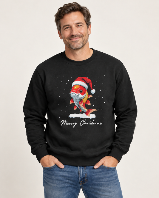 A man wearing a black crewneck sweatshirt with a festive graphic of a Koi Carp in a Santa hat and the text 'Merry Christmas' underneath, paired with blue jeans in a studio setting.