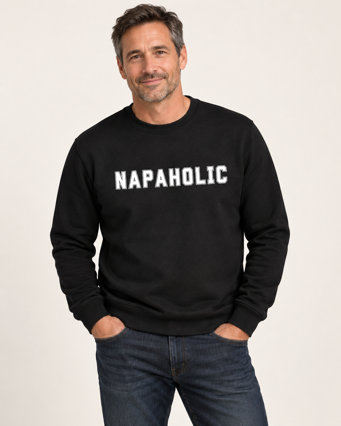 A man wearing a black crewneck sweatshirt with 'NAPAHOLIC' printed in white across the chest, paired with dark blue jeans - studio setting.
