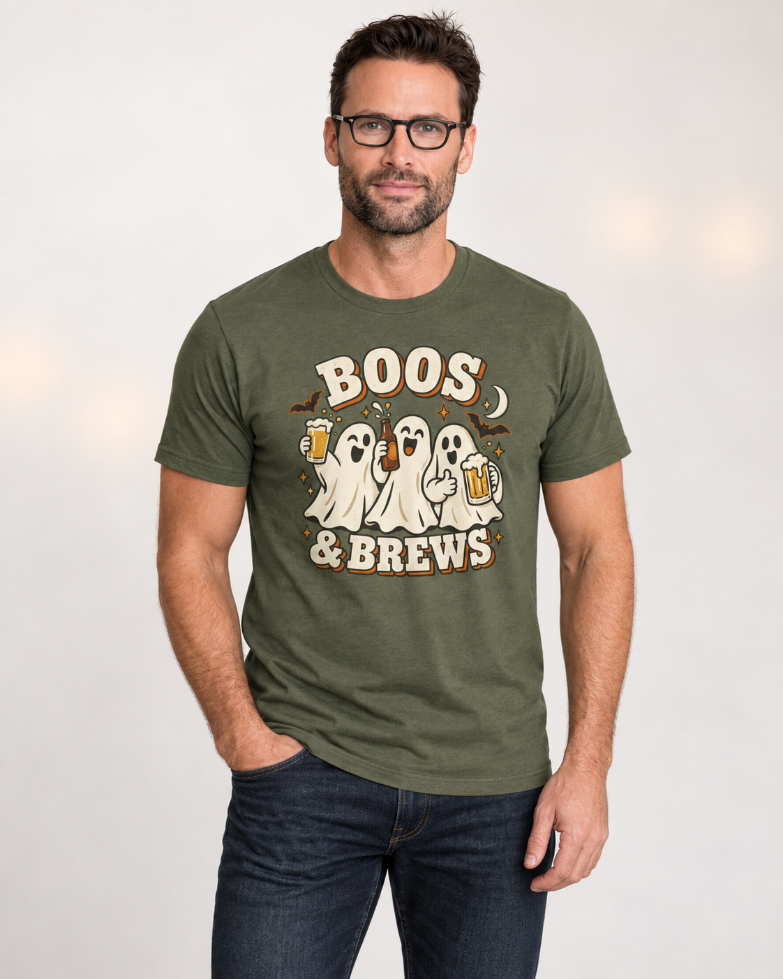 Man wearing a military-green Boos and Brews ghost Halloween T-shirt with dark jeans