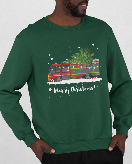 A man wearing a dark green crewneck sweatshirt with a festive Christmas graphic of a fire truck carrying a Christmas tree, with 'Merry Christmas!' written below.
