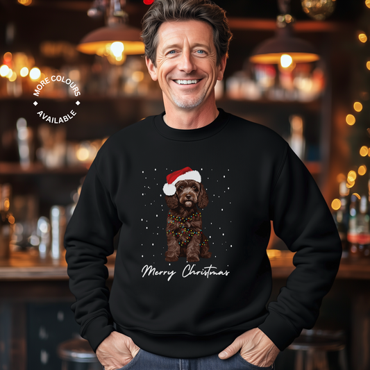Man wearing a black Christmas sweater with a chocolate brown cockapoo illustration and 'Merry Christmas'.