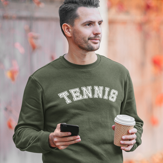 Man wearing an earthy green college-style TENNIS crewneck sweatshirt holding a coffee outdoors.