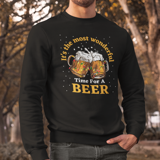A man wearing a Christmas sweatshirt with two clinking beer mugs, Christmas lights, snow, and the phrase "It’s the most wonderful time for a beer."