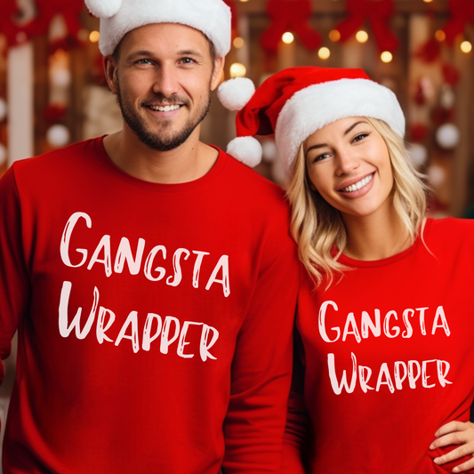 A man and a woman wearing red Christmas sweatshirts with 'GANGSTA WRAPPER' text printed on the front.