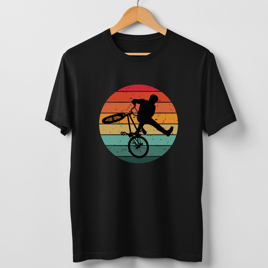 Men's black t-shirt with a silhouette BMX rider against a colourful sunset background graphic, hanging on a wooden hanger.