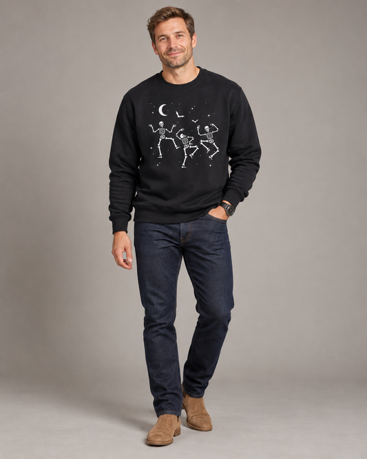 Man wearing a black dancing skeletons Halloween sweatshirt with dark jeans and tan boots.