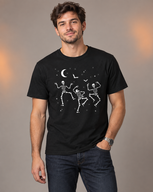 Young man wearing a black Halloween T-shirt featuring three dancing skeletons, bats and a crescent moon.