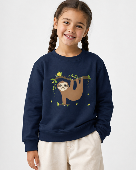 Happy 6-year-old girl wearing a navy kids sloth sweatshirt with a sloth hanging from a leafy branch with yellow flowers, styled with stone wide-leg trousers.