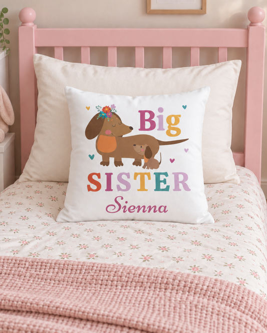 Personalised Big Sister Sienna dachshund cushion displayed on a pink wooden toddler bed with floral bedding.