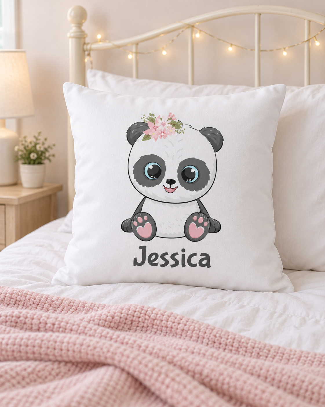 Personalised floral panda cushion with the name Jessica displayed on a cream metal bed with fairy lights