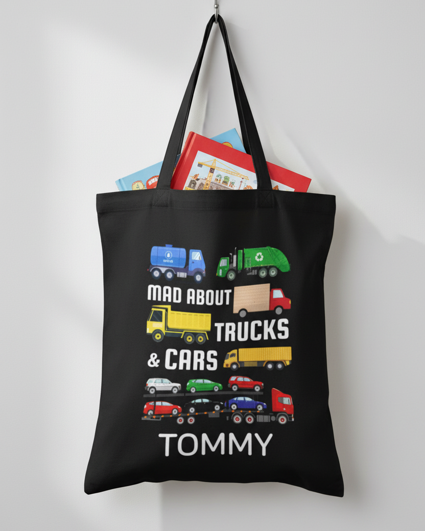 Personalised kids black tote bag with “Mad About Trucks & Cars” design and name Tommy, hanging on a hook with books inside