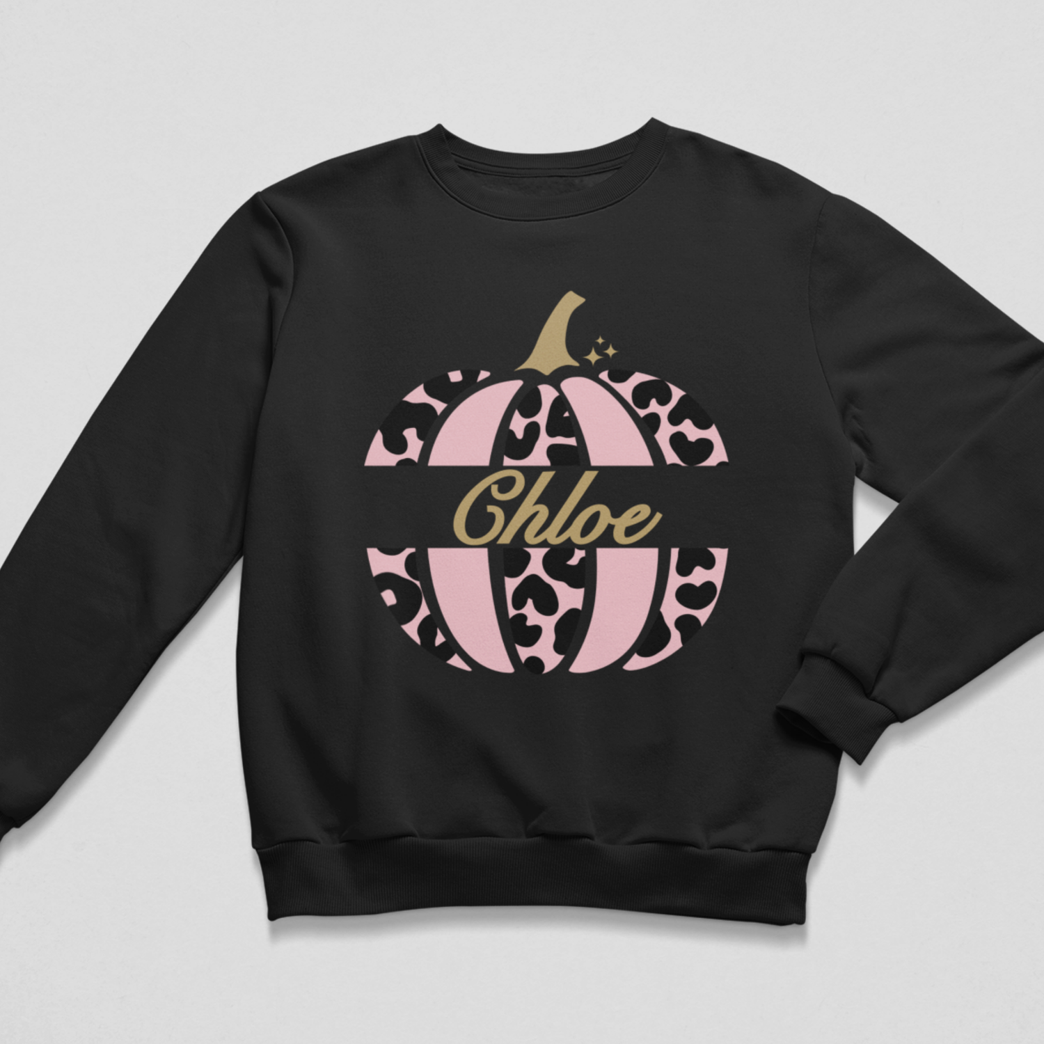 Personalised black kids’ Halloween sweatshirt with a pink leopard-print pumpkin and the name Hannah, displayed on a wooden hanger.