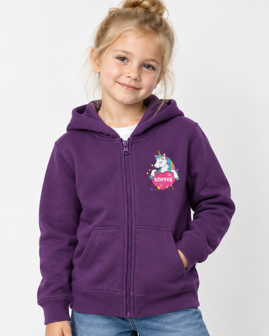 Young girl wearing a purple personalised zip hoodie with a unicorn over a pink heart and custom name printed on the chest.