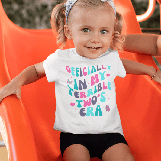 Toddler girl on slide wears "Terrible Two's Era" White T-shirt