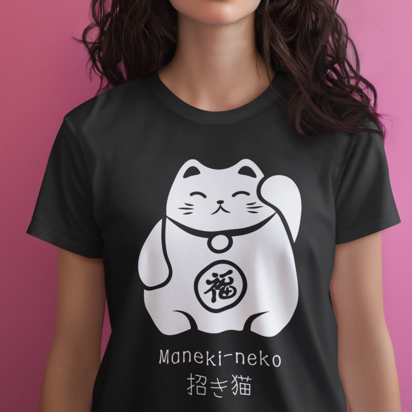 Woman wearing a black Maneki-neko Japanese Lucky Cat T-shirt, standing in front of a pink background.