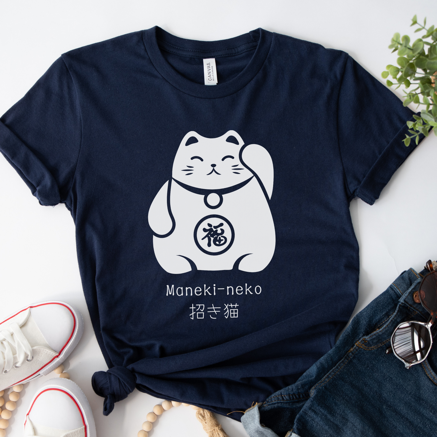 Adults navy cotton t-shirt featuring a printed graphic of a Maneki-neko Japanese Lucky Cat, styled with jean shorts and white pumps.