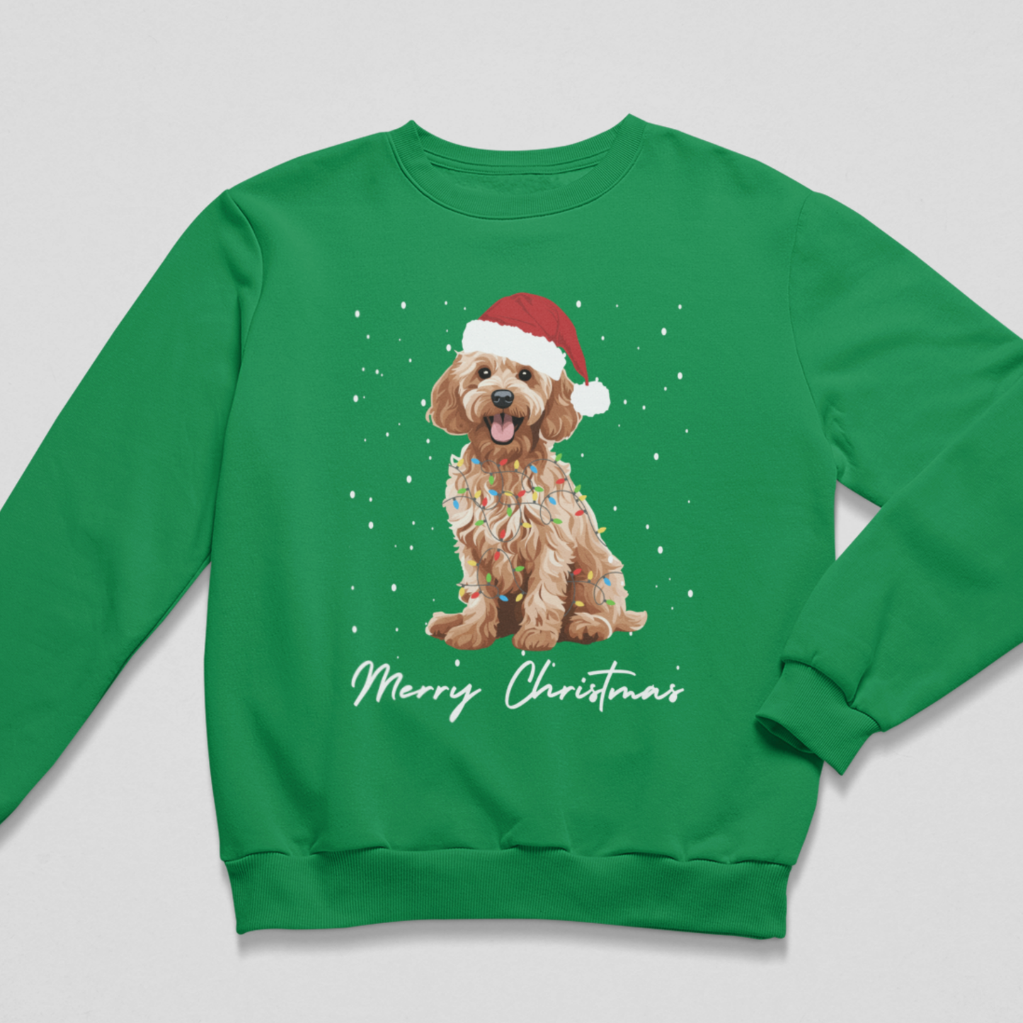 A kids green crewneck sweatshirt featuring a graphic of a golden cockapoo wearing a red Santa hat and holiday lights, with 'Merry Christmas' written in white script below, displayed on a light grey background.