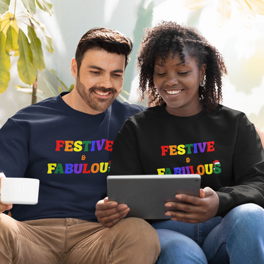 Couple wearing LGBTQ+ Pride “Festive & Fabulous” Christmas jumpers in rainbow letters