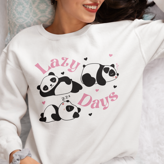 Woman wearing a white Lazy Days panda sweatshirt with cute sleeping panda print in a cozy indoor setting