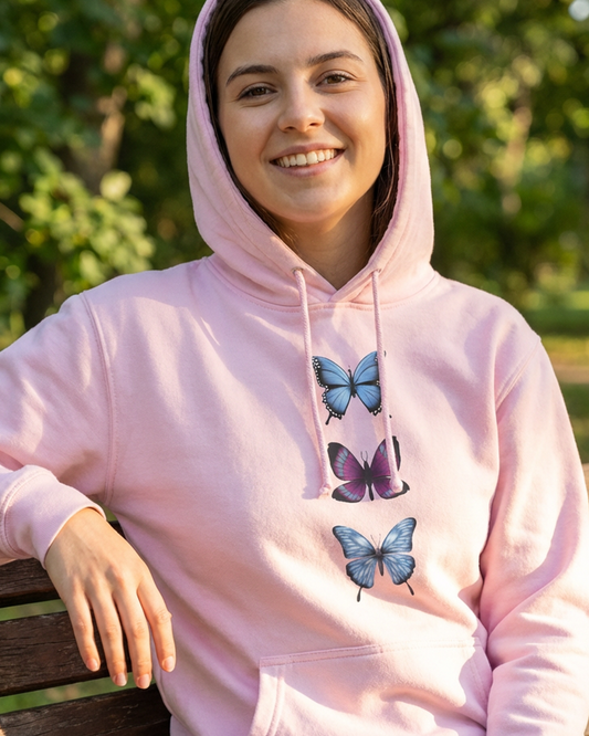 Baby pink butterfly trio hoodie worn by a woman outdoors