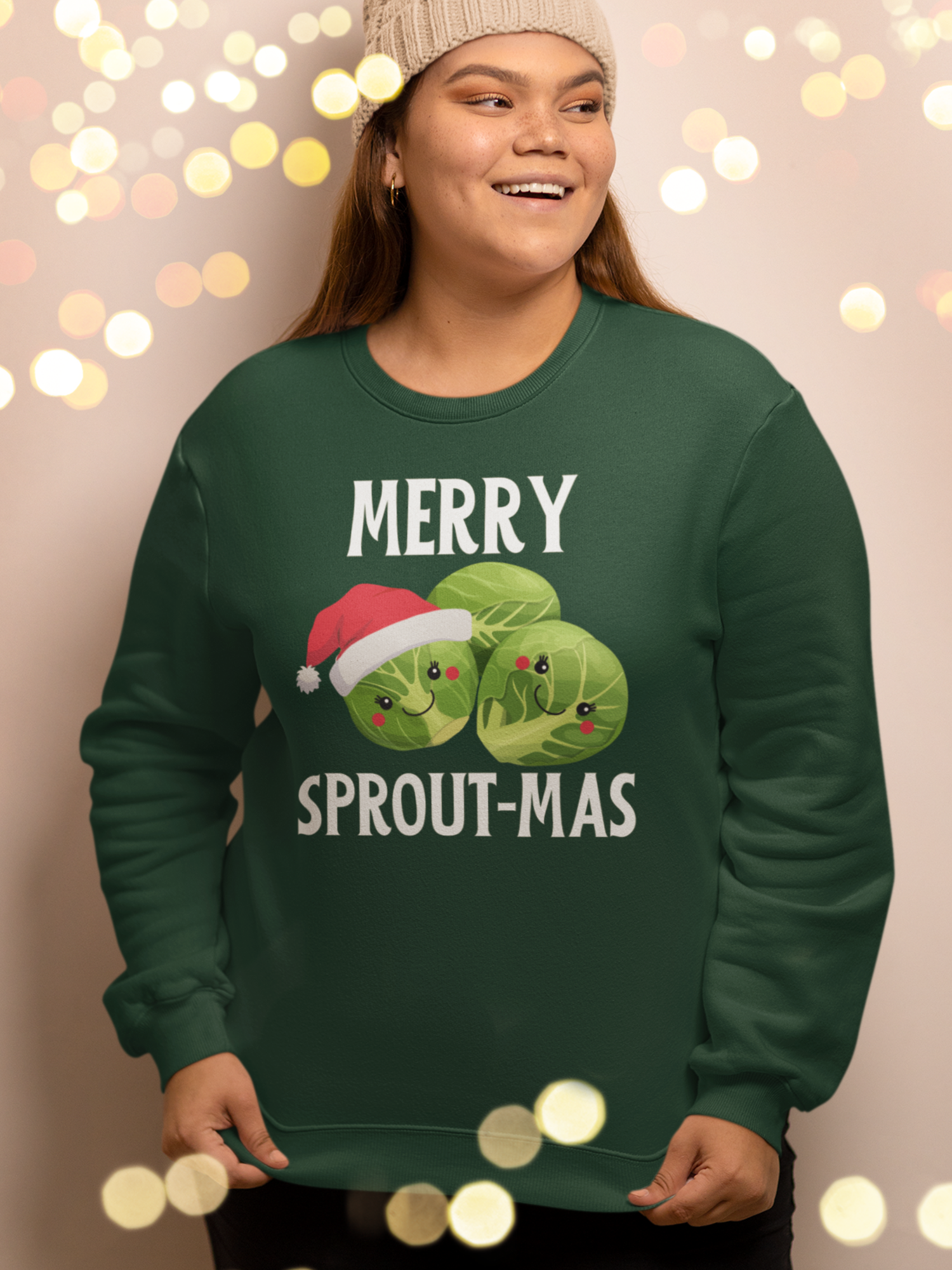 Woman wearing a dark green “Merry Sprout-mas” Christmas sweatshirt with cute Brussels sprouts and a Santa hat design.