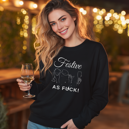 Woman wearing a black Christmas sweatshirt with “Festive As F*ck” slogan and minimal wine glass illustration, holding a glass of white wine