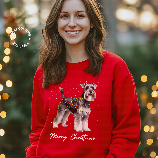 Woman wearing a red Christmas sweater with a festive Schnauzer design and 'Merry Christmas' text, standing in front of a blurred festive background.