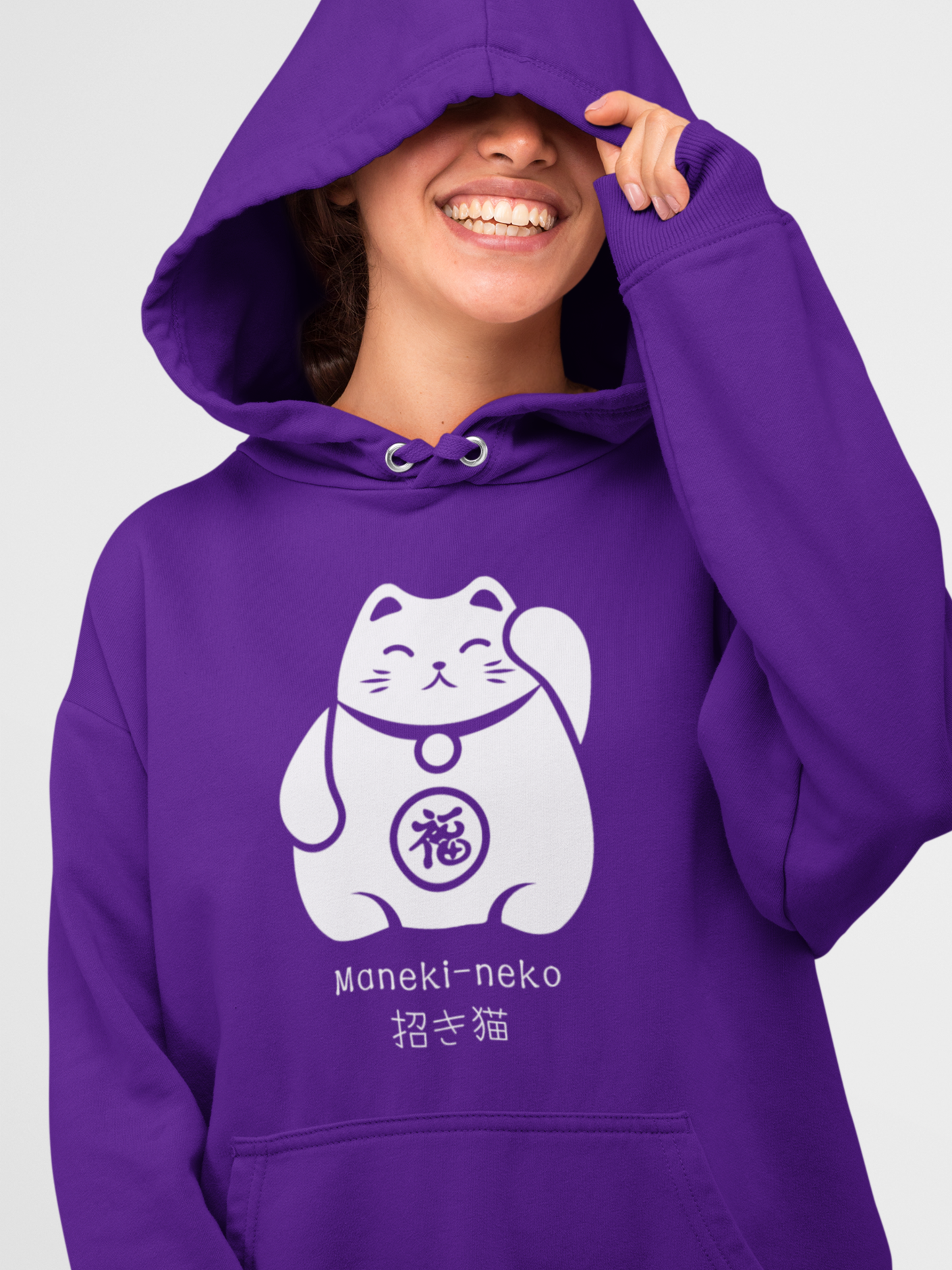 Woman wearing a purple Maneki-neko Japanese Lucky Cat hoodie, smiling with the hood up and a white lucky cat graphic on the front.