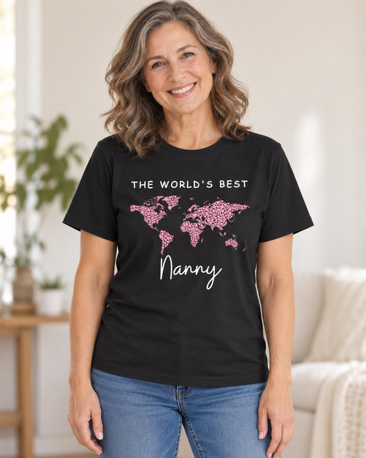 Smiling woman wearing a black crew neck t-shirt featuring "The World's Best Nanny" printed in white text alongside a world map made from small pink hearts.
