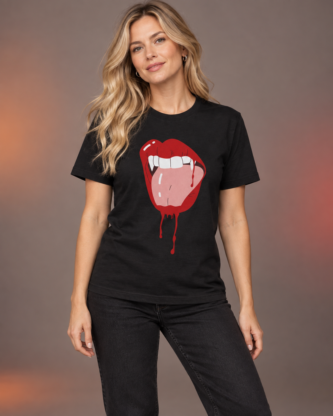 Blonde woman wearing a black Halloween T-shirt featuring red vampire lips, white fangs and dripping blood, styled with black jeans.