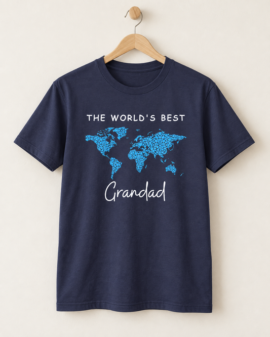 Navy “The World’s Best Grandad” T-shirt with a blue heart world map displayed on a natural wooden hanger.