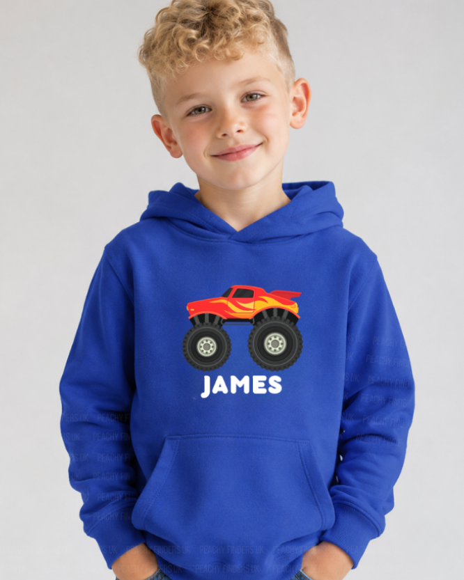 Young boy wearing a royal blue personalised monster truck hoodie with custom name Harvey, shown in a natural studio-style kids hoodie. 