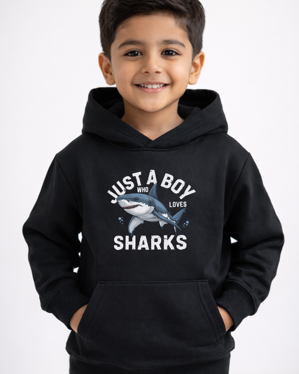 Boys black shark hoodie with “Just A Boy Who Loves Sharks” print, worn by smiling child in clean studio setting