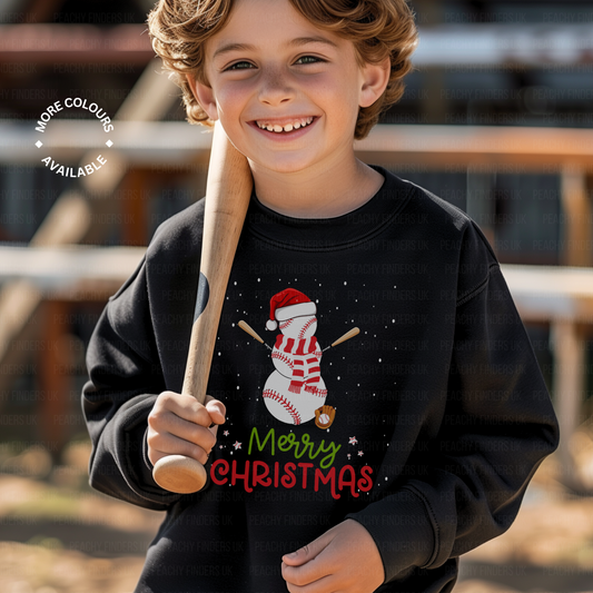 Child wearing a black Christmas-themed sweatshirt with a snowman baseball design and 'Merry Christmas' text, holding a baseball bat.