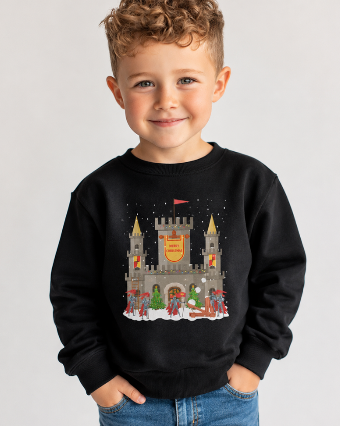 Boy modelling a black sweatshirt with a Christmas castle with guarding knights winter scene and a Merry Christmas banner.