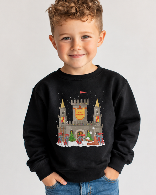 Boy modelling a black sweatshirt with a Christmas castle with guarding knights winter scene and a Merry Christmas banner.