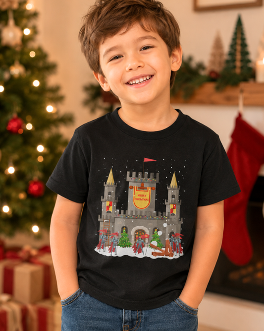 Young boy wearing a black Christmas castle and knights t-shirt in a festive holiday setting