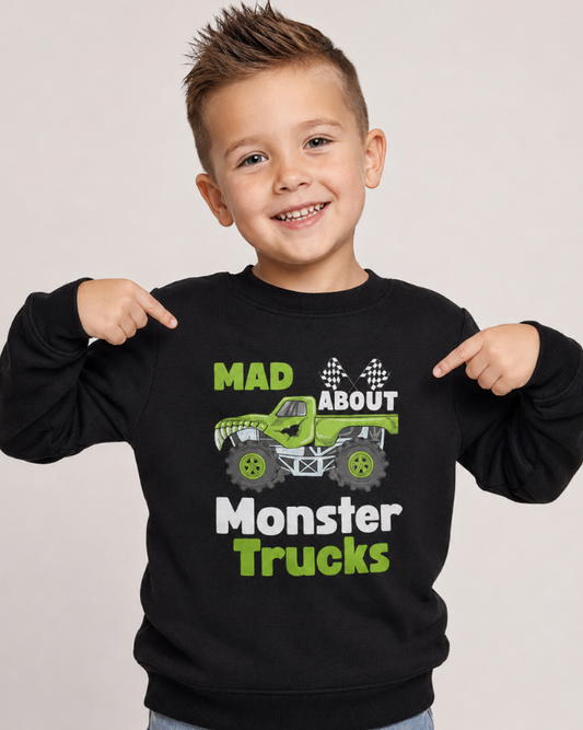 Child wearing a black sweatshirt with "Mad About Monster Trucks" design - studio setting