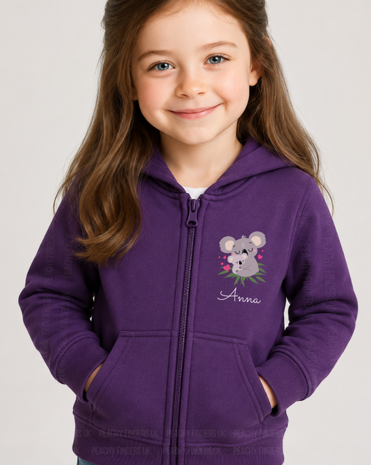 Young girl wearing a purple hoodie with a koala design and name 'Anna' on a plain background