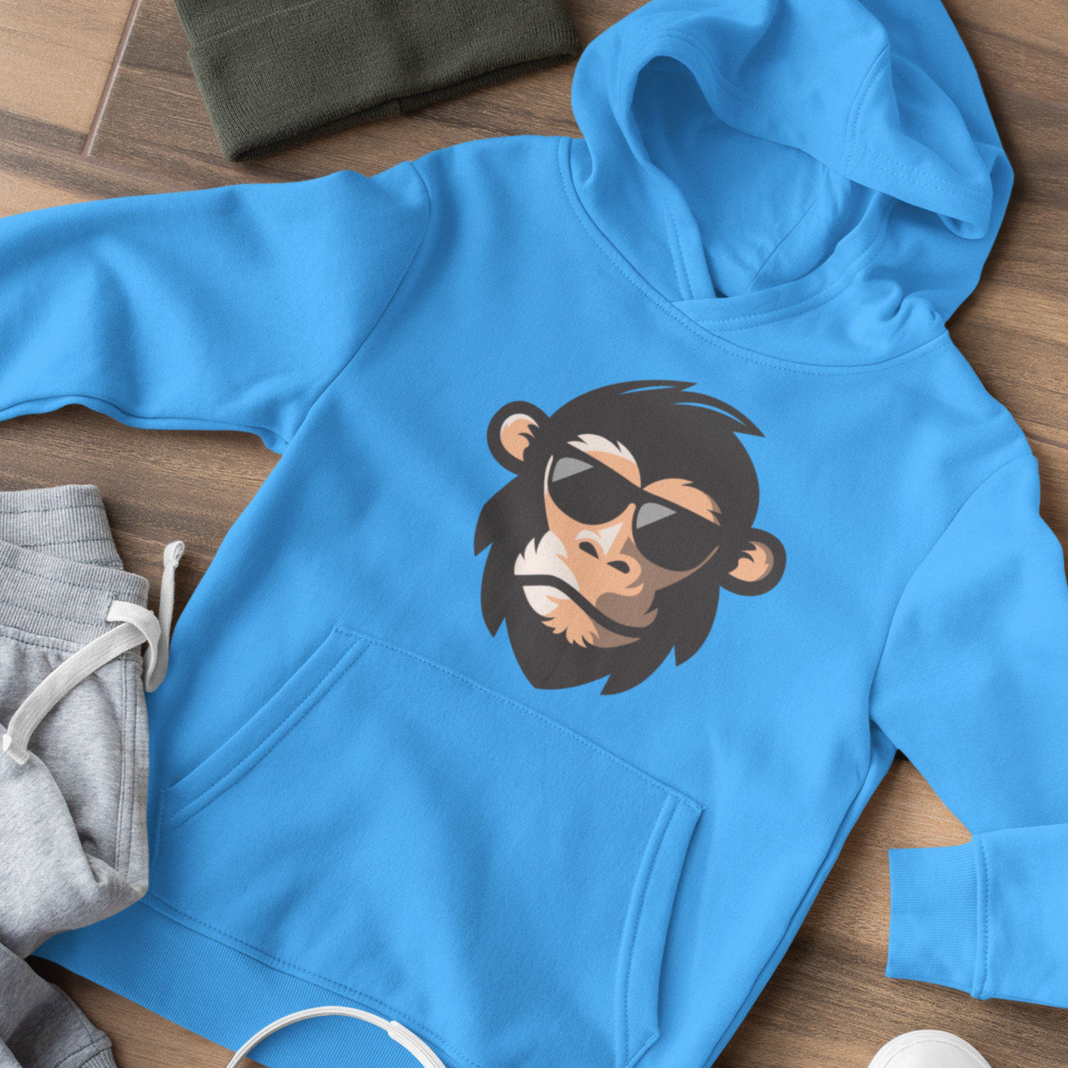 A cool chimp wearing sun glasses on a bright blue child's hooded sweatshirt