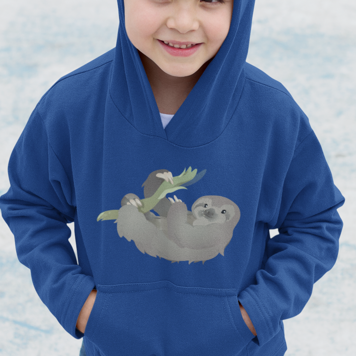 Cute sloth hanging from a branch on a blue child's hooded sweatshirt