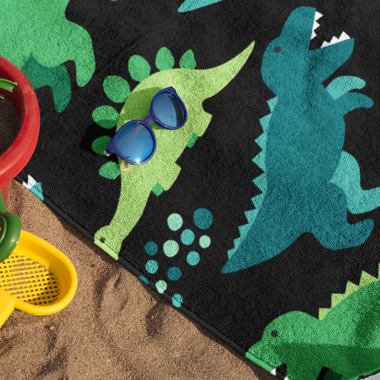 Kids Dinosaur Patterned Beach Towel. Blue and Green Dinosaurs on a Black Background.