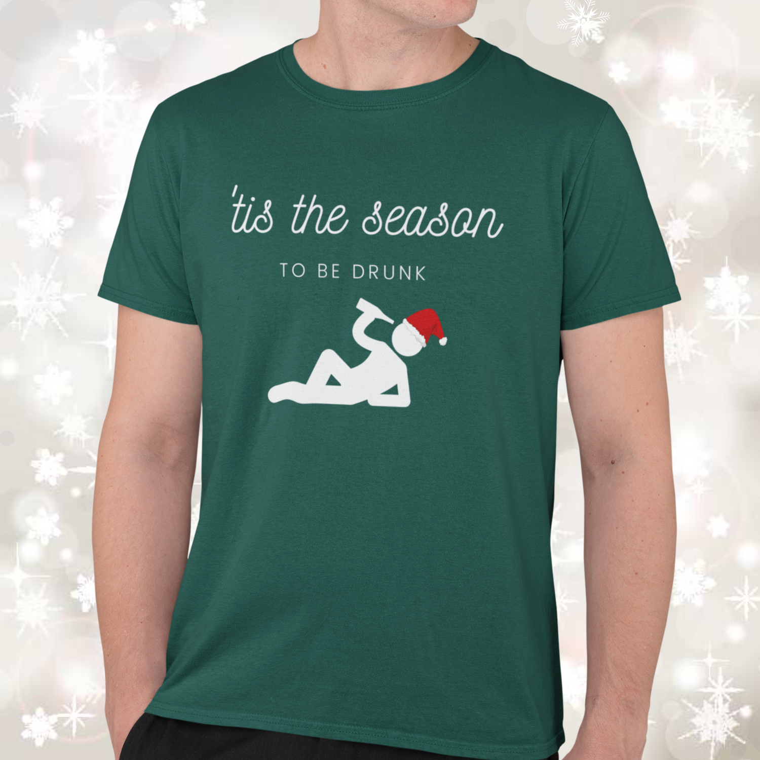 Man wearing a green Christmas t-shirt with the words "tis the season to be drunk" 