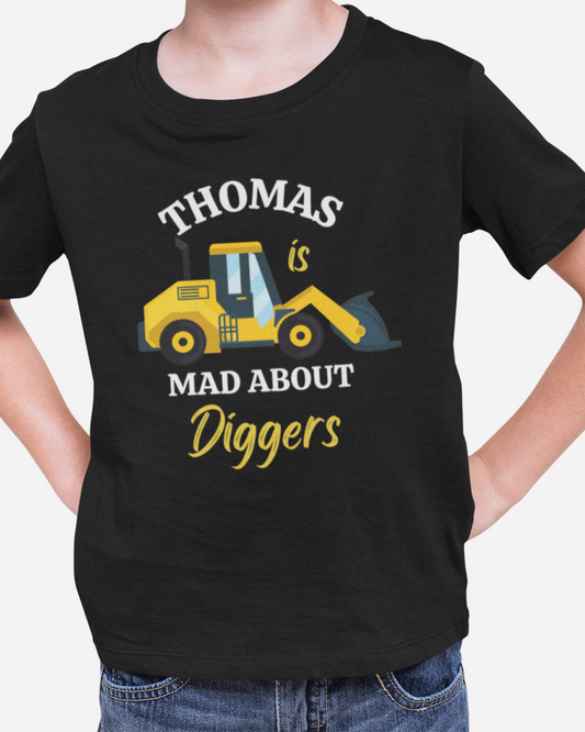 Boys models a black t-shirt with yellow digger illustration and personalised slogan Thomas is mad about diggers printed on the front.