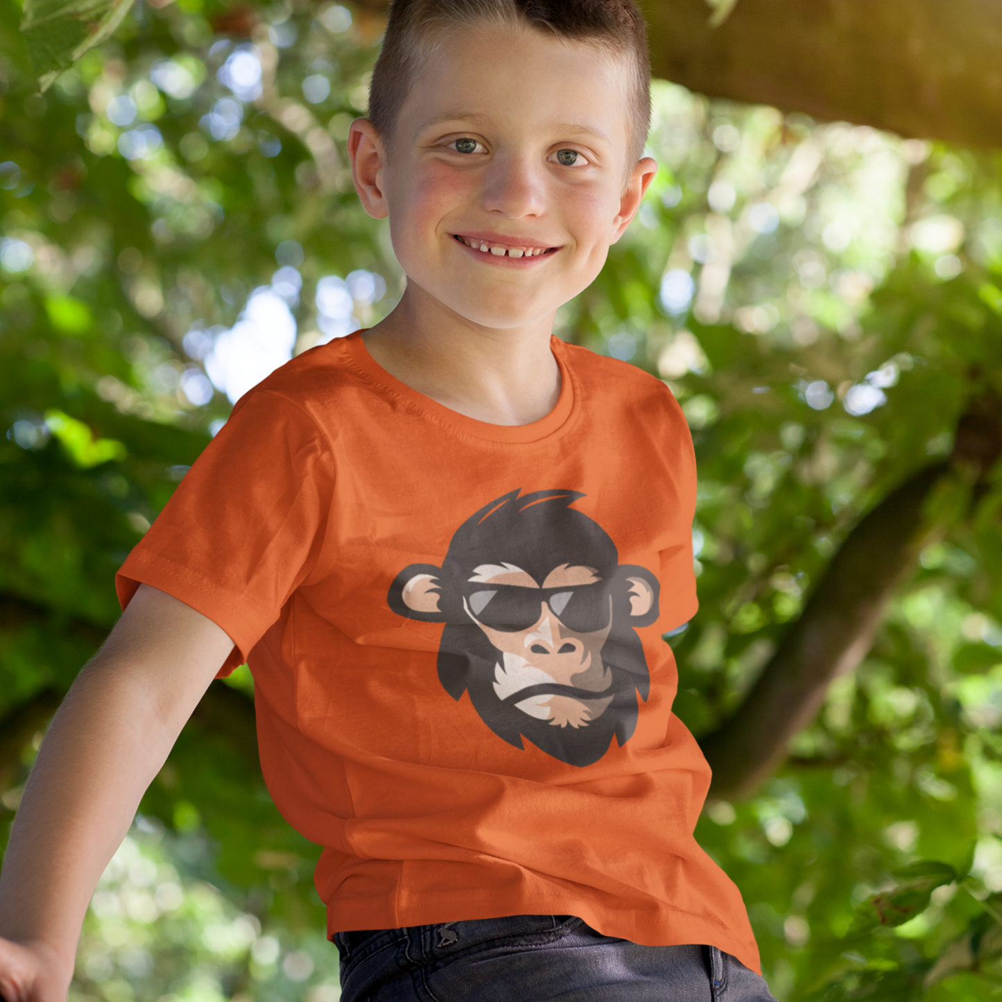 Boy wearing orange t-shirt with cartoon chimp with sun-glasses